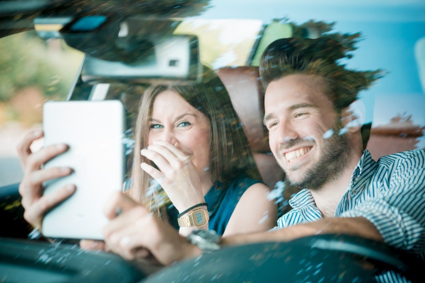 young beautiful couple lovers using tablet in the car travel