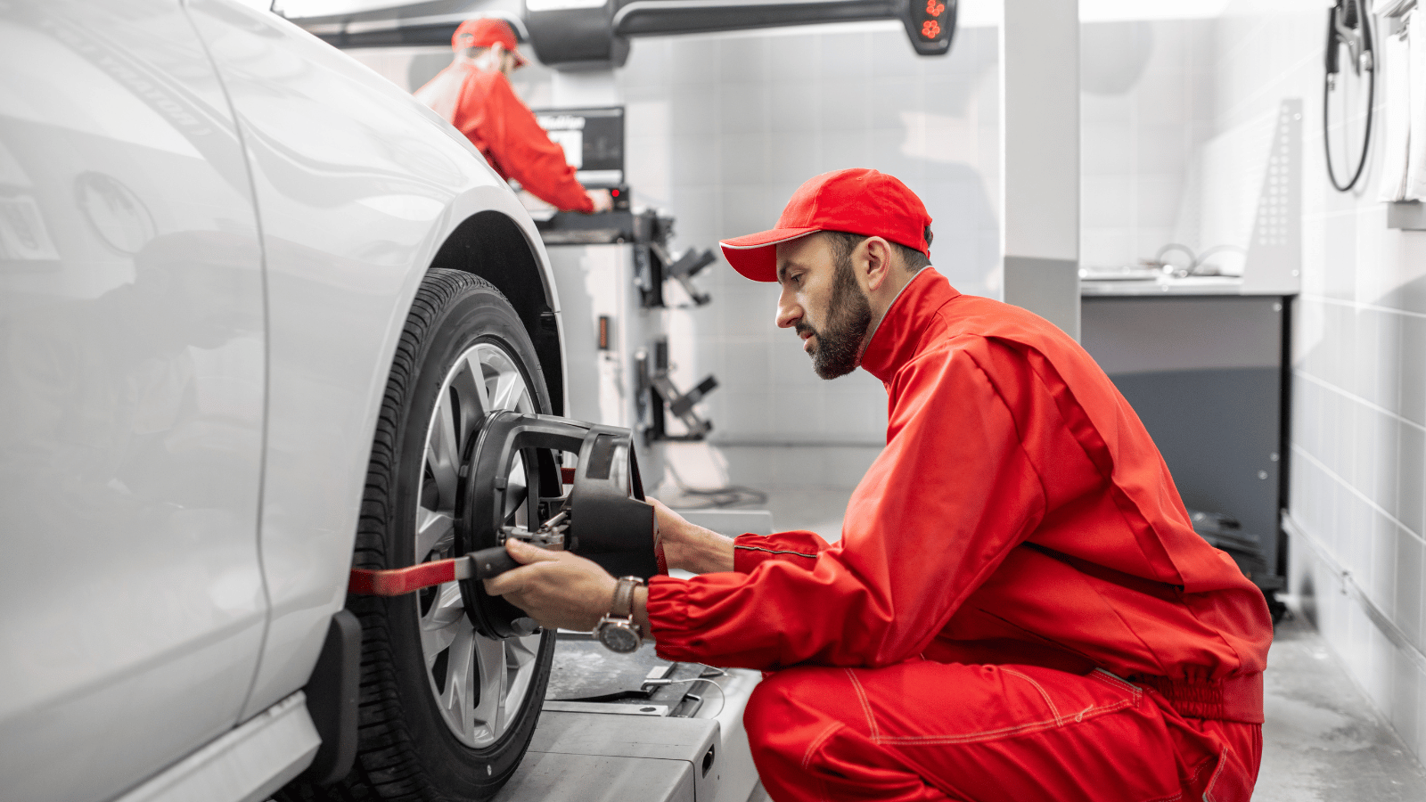 Mechanic checking the wheel and brakes of an electric car