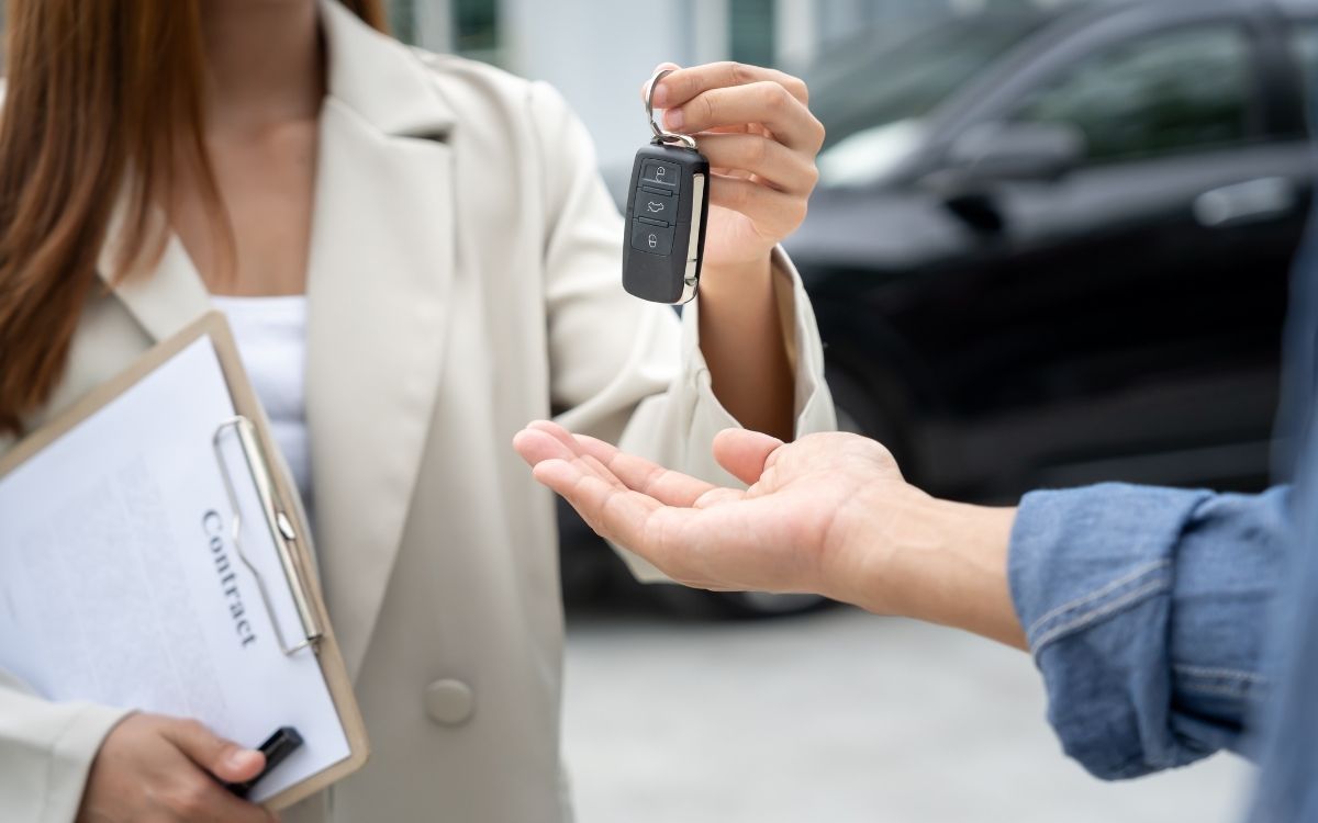 A used-car buyer inspecting a vehicle on a forecourt